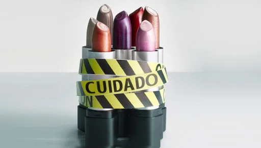 Pintalabios de varios colores rodeados de cinta de peligro amarilla y negra con la palabra CUIDADO
